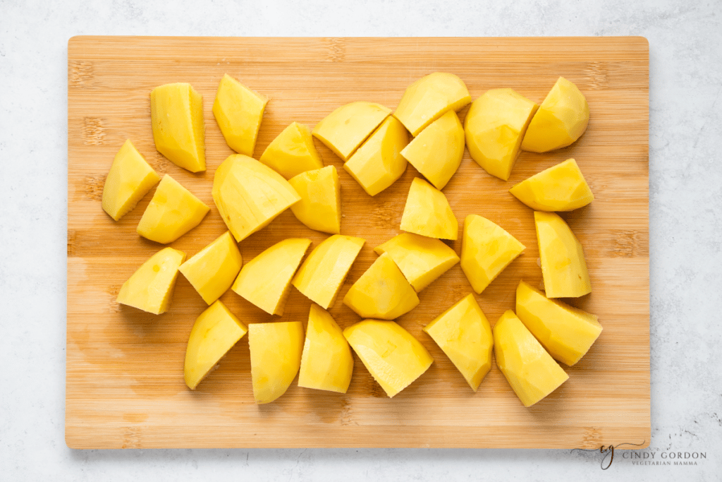yellow potato cubes in wooden cutting board