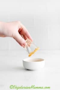 dipping shot glass into graham crackers crumbles.