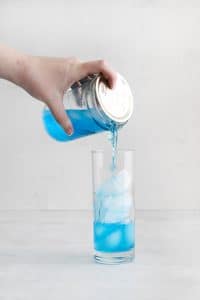 ball jar pour blue liquid into tall clear glass