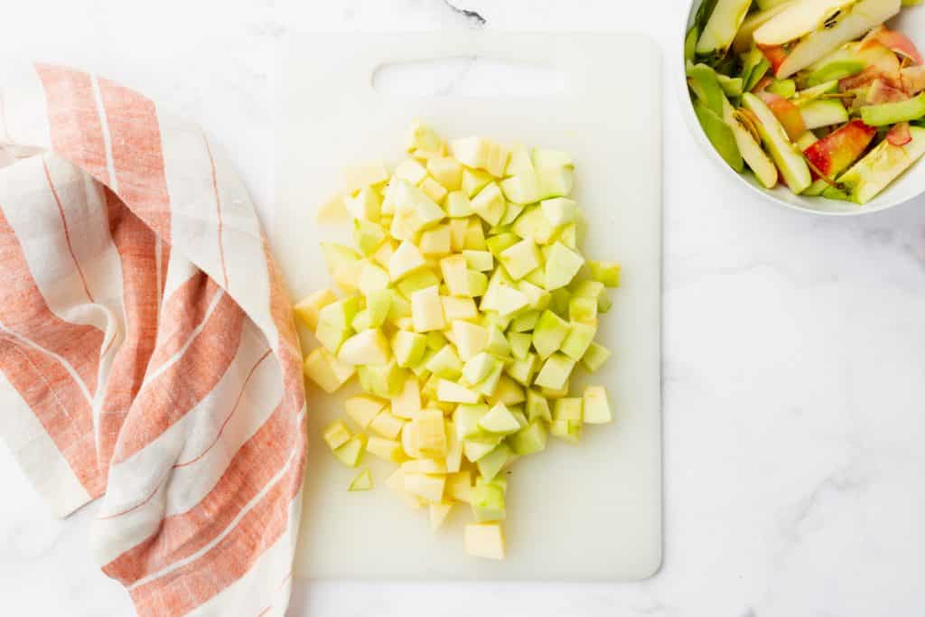 a cutting board filled with diced apples.