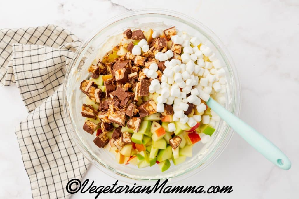 apple, snicker bits, and marshmallows in a bowl