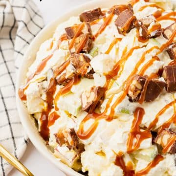white bowl with apples and snicker bites.