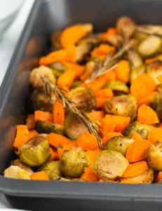 closeup of finished roasted veggies with rosemary sprig