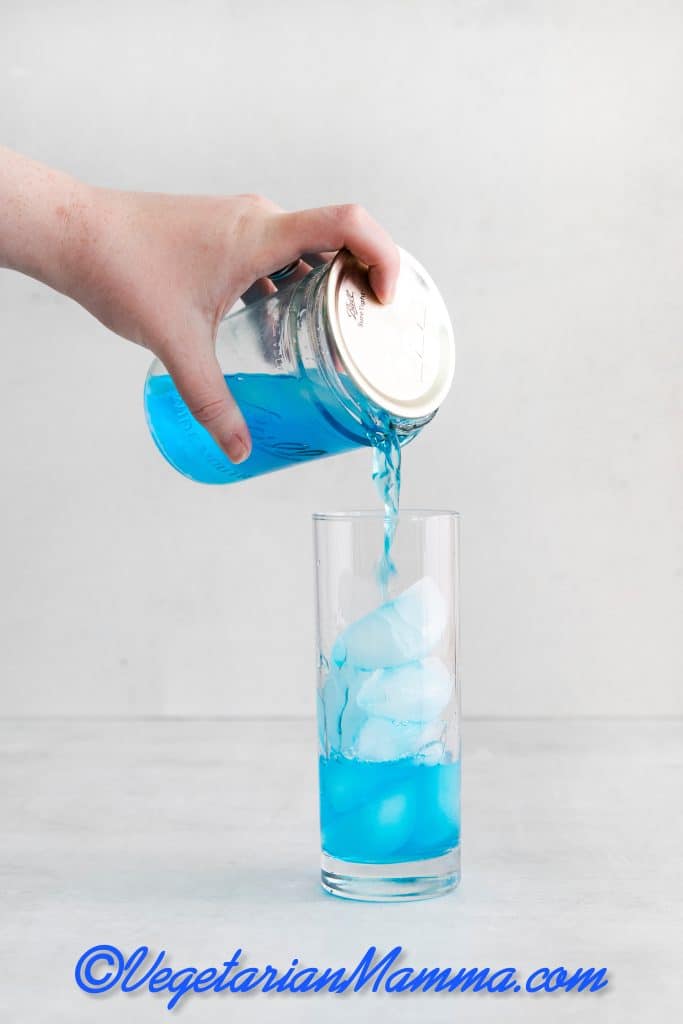 Fill two highball glasses with ice and divide the mixture between the glasses.