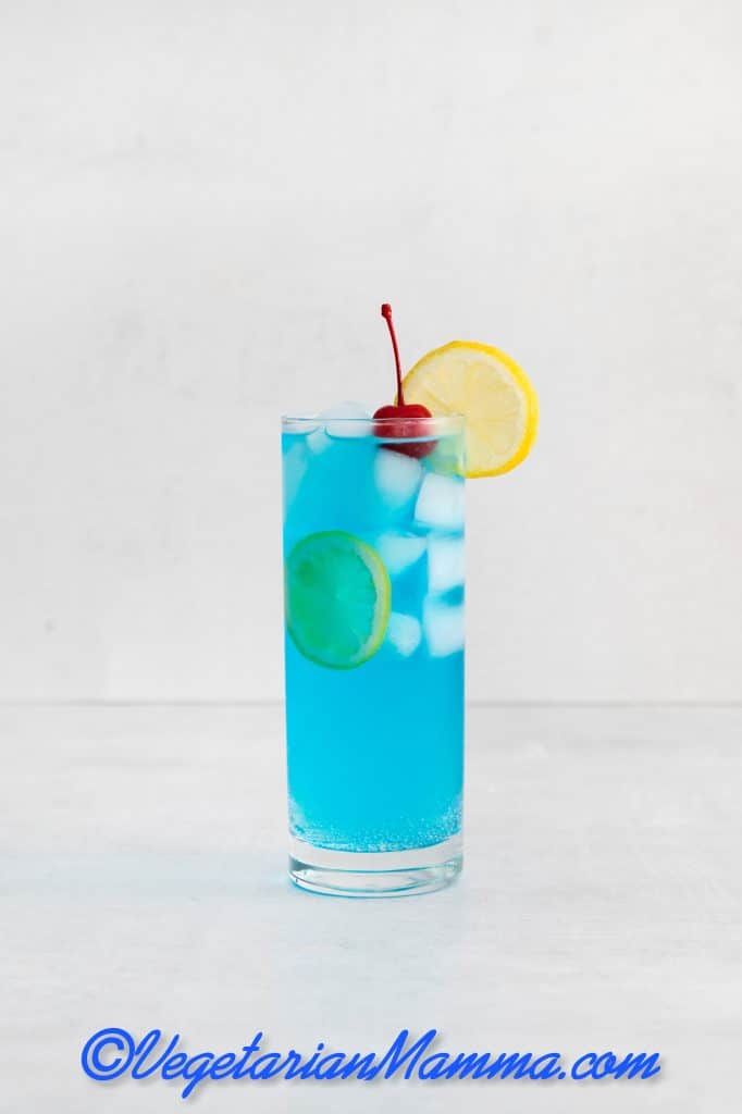 Garnish with a lemon wheel and maraschino cherry.