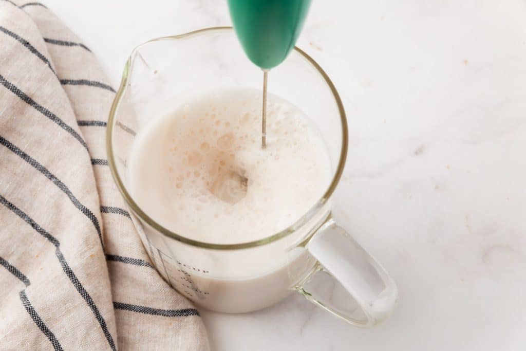 Milk frothed in a measuring cup using an electric frother