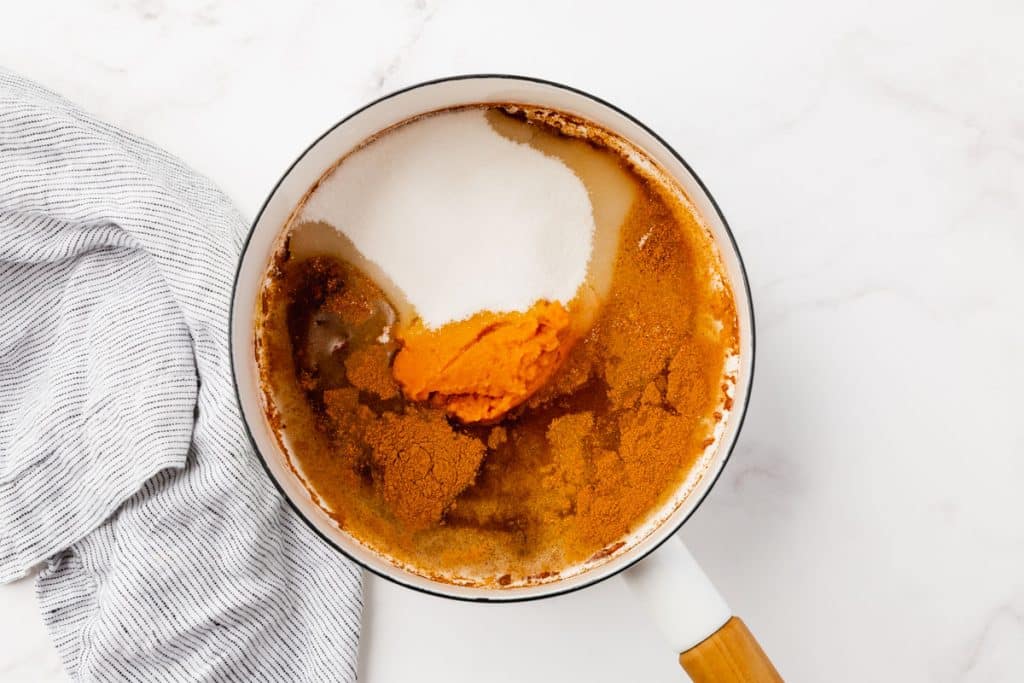 granulated sugar, water, pumpkin puree, ground cinnamon, ground ginger, nutmeg, allspice, and cloves in a saucepan