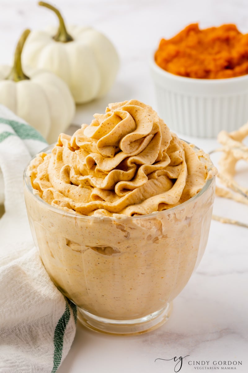 a small glass bowl filled with pumpkin whipped cream, piped into a swirl on top