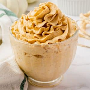 a small glass bowl filled with pumpkin whipped cream, piped into a swirl on top