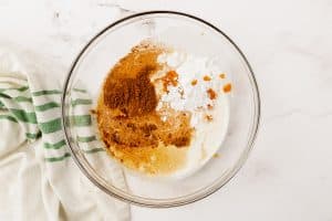 a bowl holding the ingredients for pumpkin whipped cream.