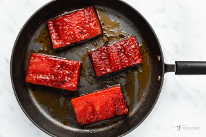 watermelon steaks cooking in a large skillet