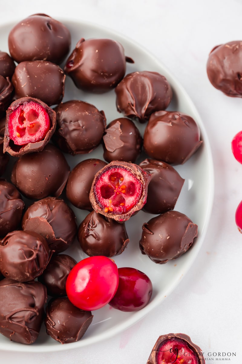 closeup of a plate filled with chocolate covered cranberries. 