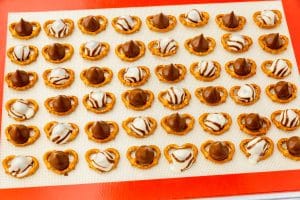 a tray of mini pretzels with melted hershey kisses.