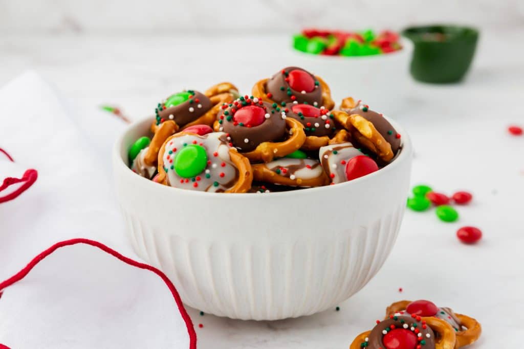 a white bowl filled with christmas pretzels.