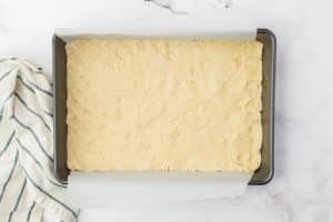 dough pressed into a baking pan to make lemon bar crust