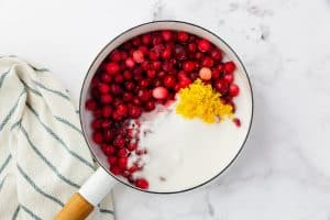 cranberries, sugar, and lemon zest in a white enameled saucepan