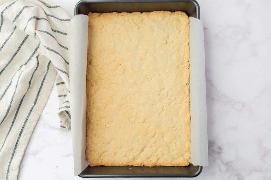 baked crust for cranberry lemon bars in a 9 by 13 inch metal pan