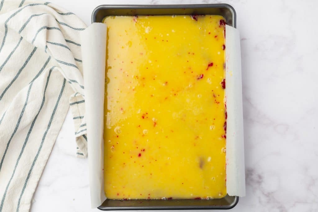 Lemon filling added to the pan for cranberry lemon bars