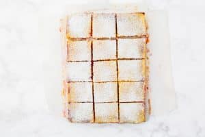 cranberry lemon bars cut into squares and sprinkled with powdered sugar