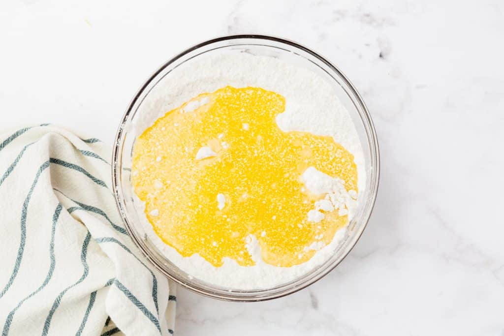 flour, sugar, melted butter in a glass mixing bowl.