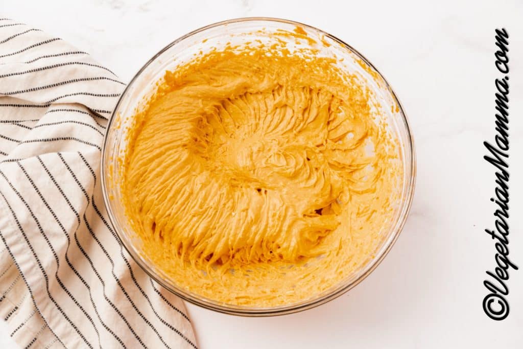 Bowl of cream cheese with pumpkin and spices mixed in.