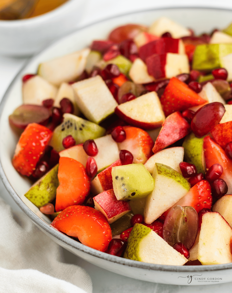 Closeup view of thanksgiving fruit salad in a white serving bowl. 