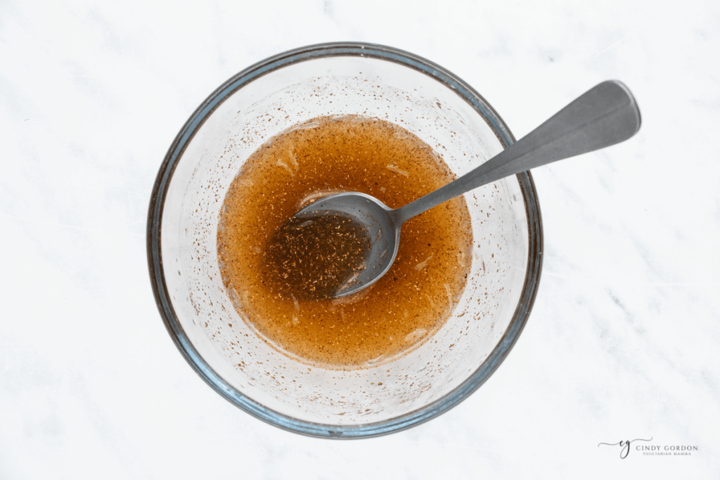 pumpkin spice fruit salad dressing in a small glass bowl with a spoon in it.