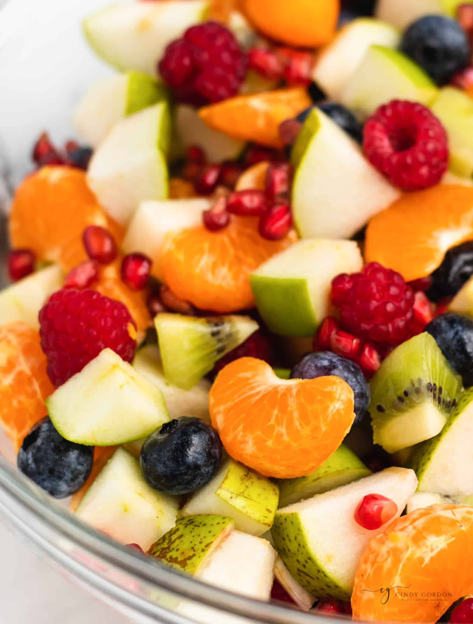 Closeup of Christmas fruit salad made with berries, tangerines, apples and pomegranate seeds