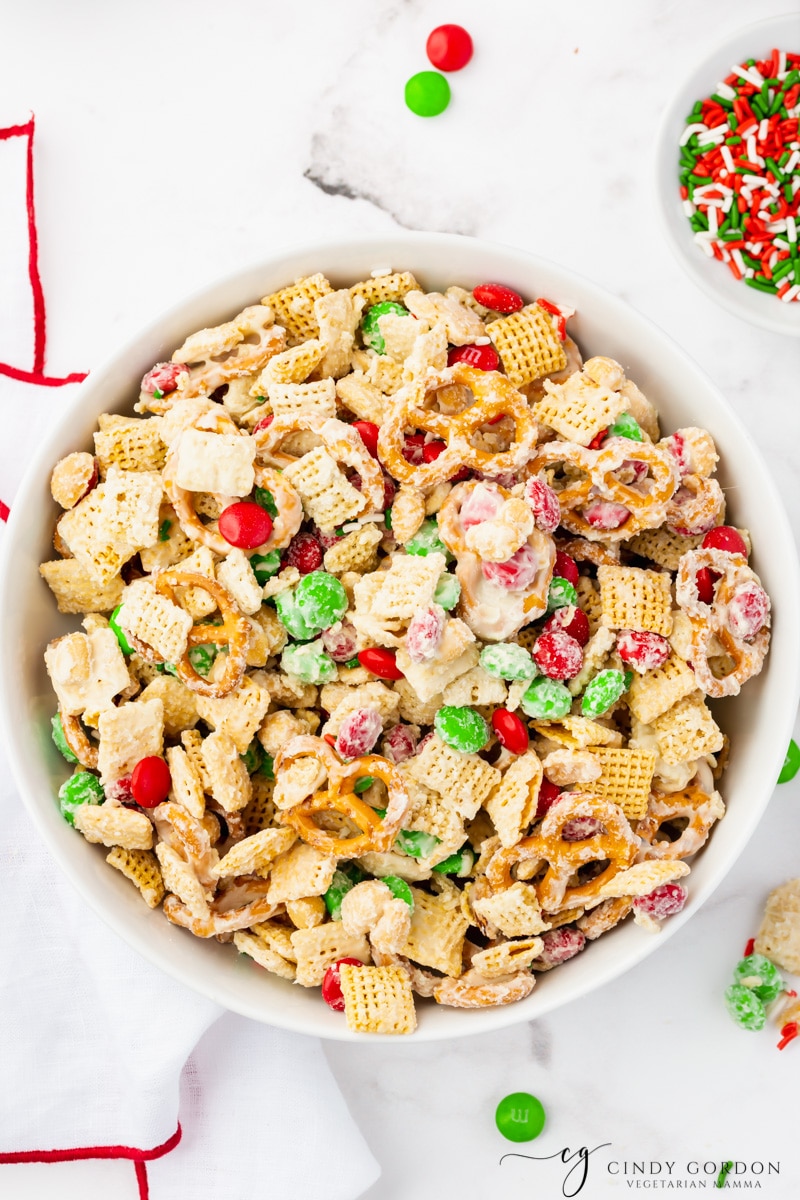 a bowl of holiday white chocolate chex mix on a table