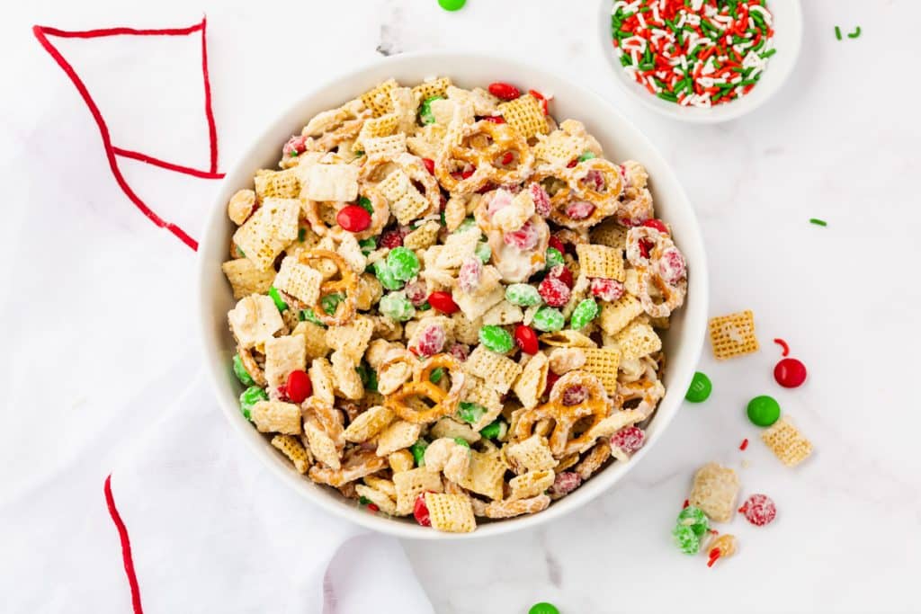 a bowl of holiday white chocolate chex mix on a table
