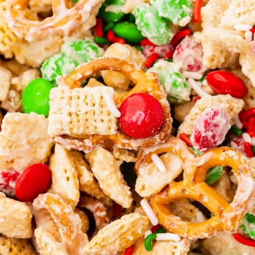 Closeup view of chex, pretzels, peanuts and m&ms coated with white chocolate.