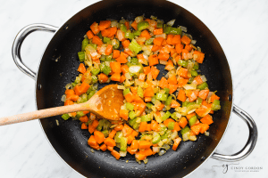 onion, carrot, and celery, diced, cooking in a pot for soup.