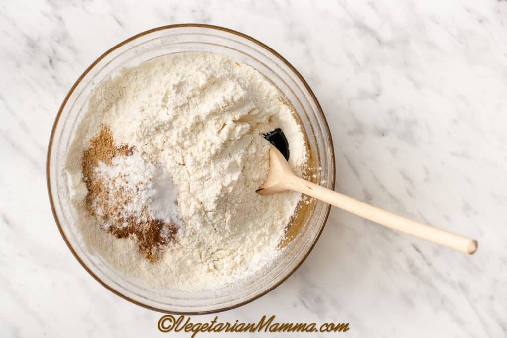 Sieve in the gluten-free flour, and add cinnamon, ground ginger, baking soda, and xanthan gum. Mix together first with a wooden spoon, then by hand to form a dough.