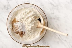 Sieve in the gluten-free flour, and add cinnamon, ground ginger, baking soda, and xanthan gum. Mix together first with a wooden spoon, then by hand to form a dough.