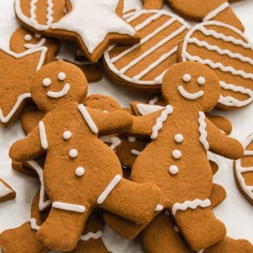 Close-up shot of 2 gingerbread people on a pile of more decorated gingerbread cookies