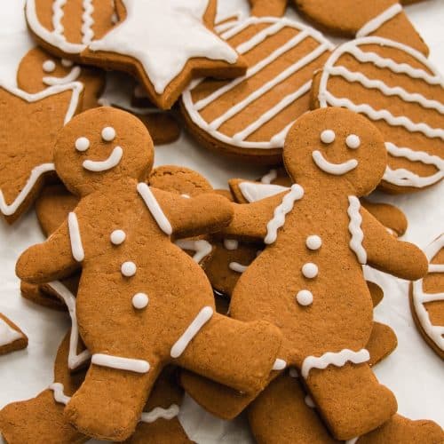Close-up shot of 2 gingerbread people on a pile of more decorated gingerbread cookies