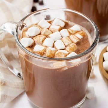 A glass mug of vegan hot chocolate with vegan marshmallows on top