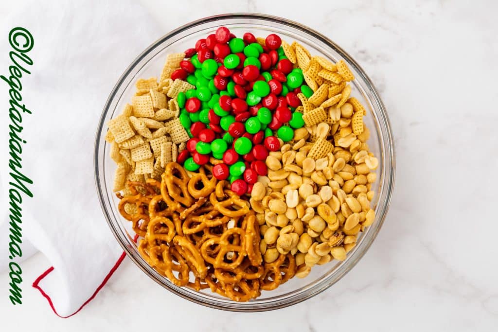 Ingredients of peanuts, pretzels, red and green M&Ms, white chocolate chips.