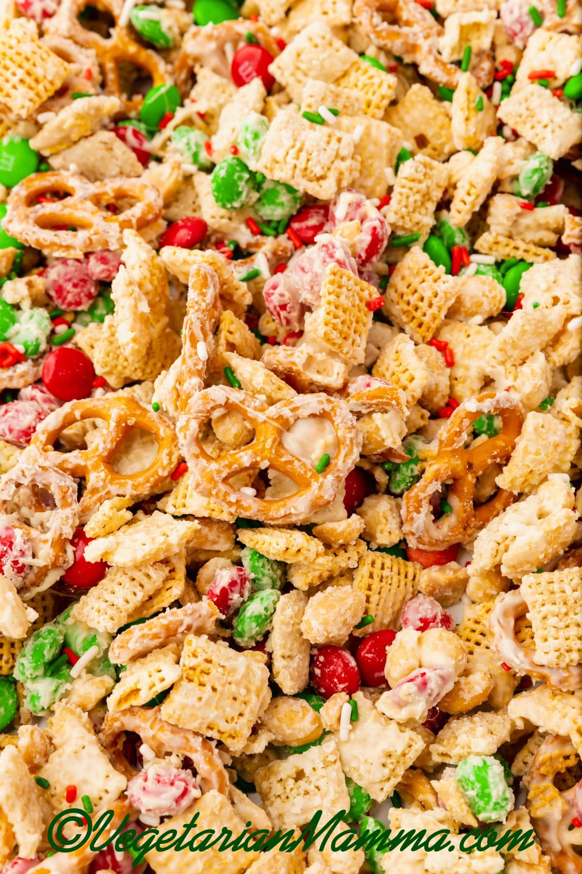 White Chocolate Chex Mix with red and green M&Ms, pretzels, and chex squres.