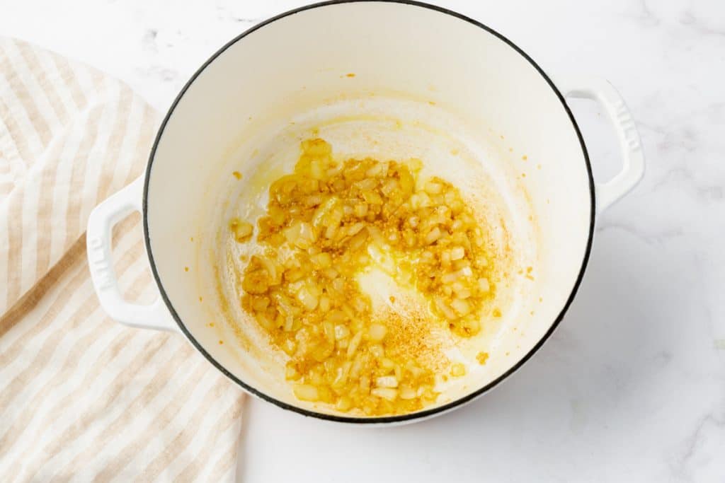 sauteed onion and garlic in a white enameled dutch oven