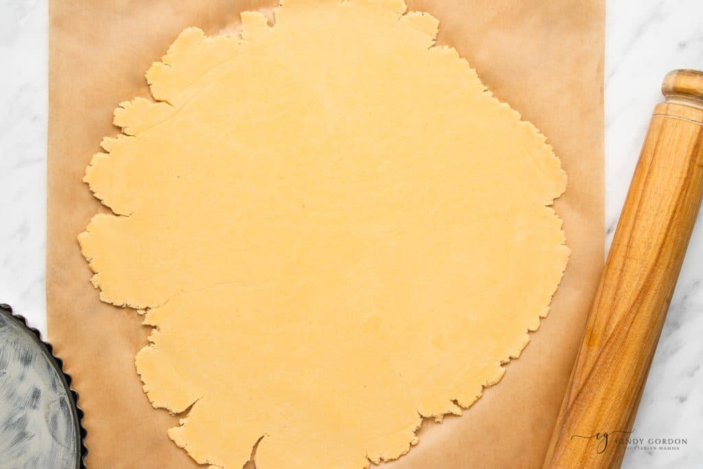 rolled pie crust on a piece of brown parchment paper