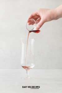 Glass with red liquid being poured in