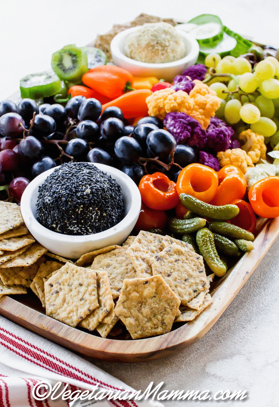  Vegetarian Charcuterie board  with fruit, vegetables, crackers, and two vegan cheese balls