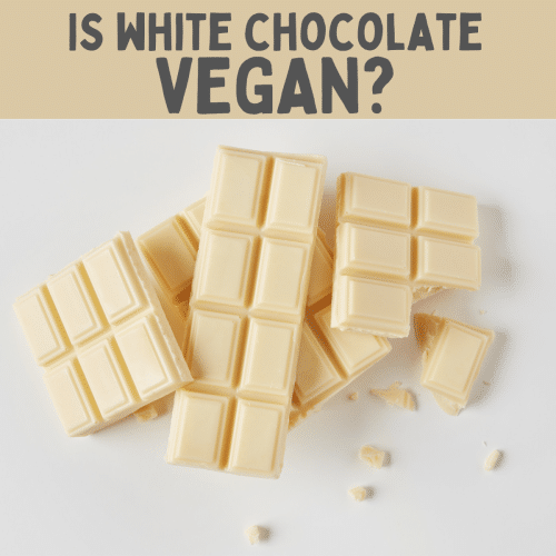 pieces of a white chocolate bar broken and piled up. Text overlay: is white chocolate vegan?