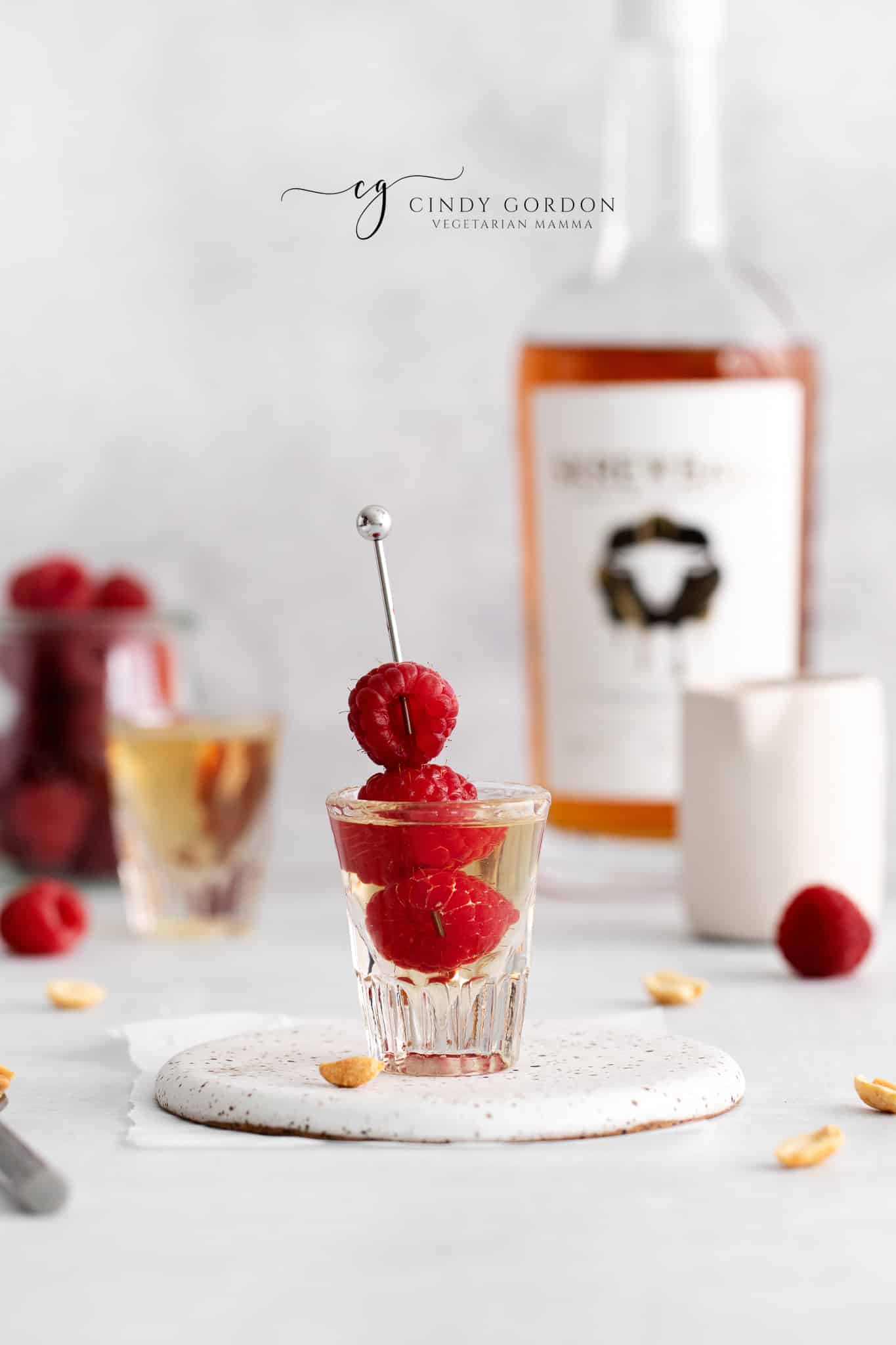 a PBJ shot with a skewer of fresh raspberries in it. 