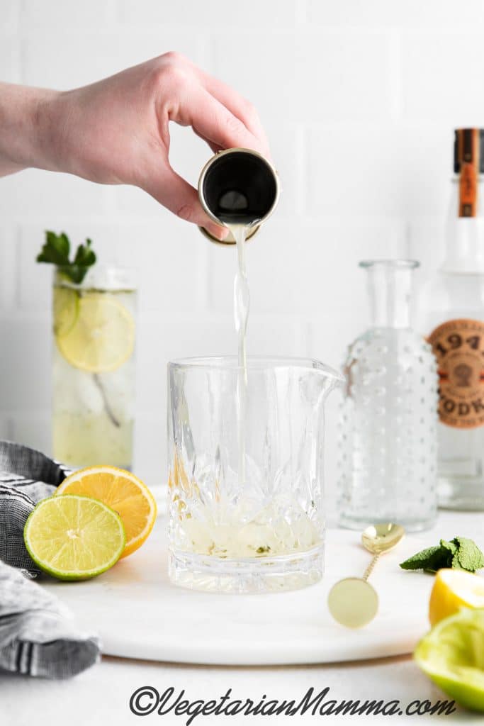 pouring mint syrup in high ball glass
