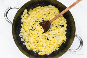 onion and potato in a stock pot, frying in oil.