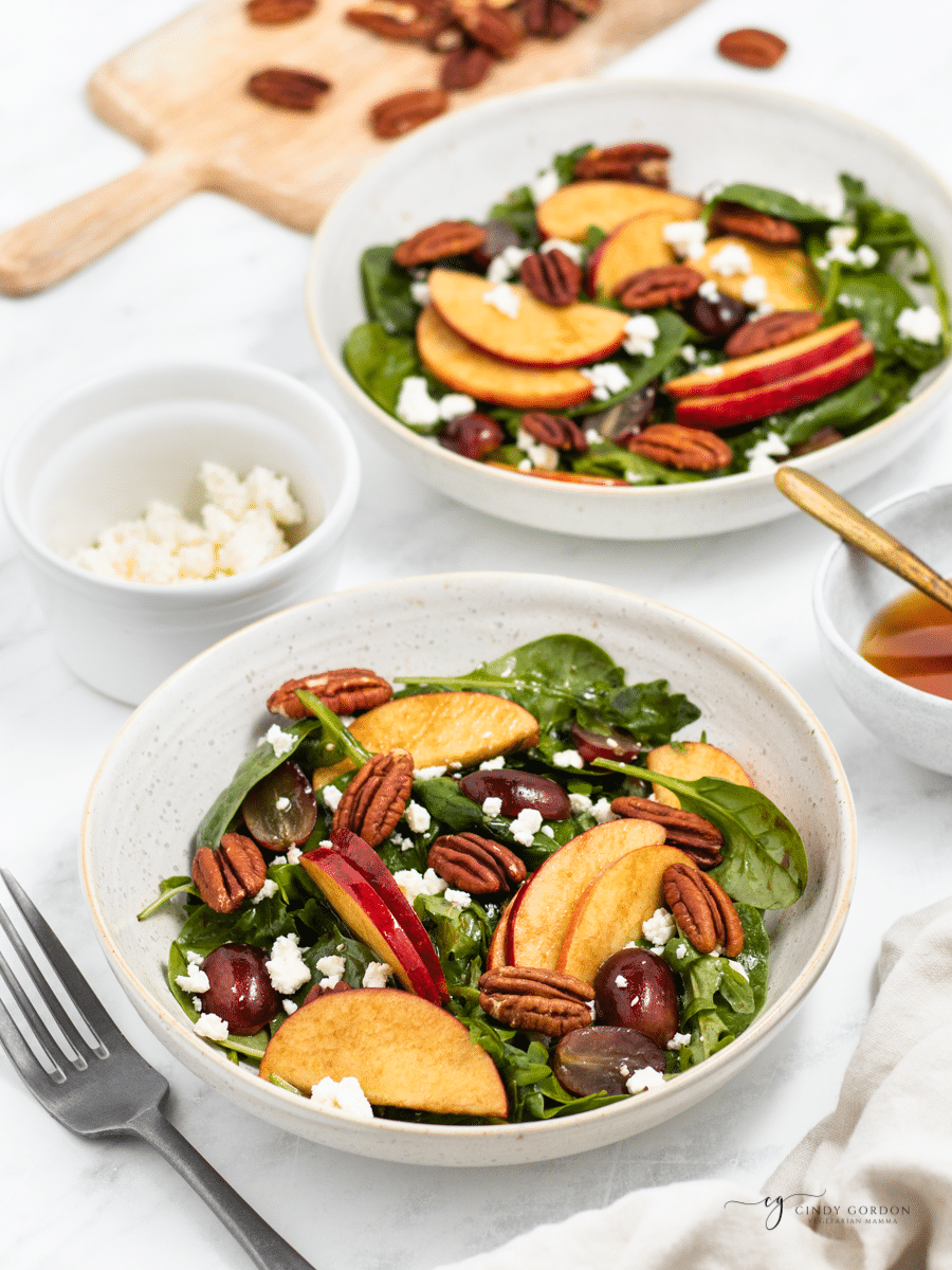 Two servings of apple pecan salad on a table. 