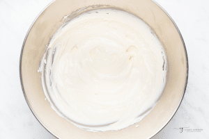cream cheese that has been whipped in a stand mixer bowl.