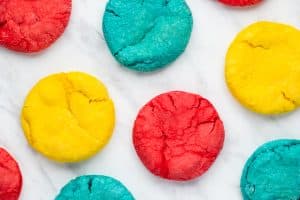 red, blue, and yellow sugar cookies on a marble counter.